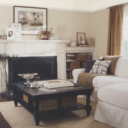 Living room with tan painted walls, black coffee table and white sectional